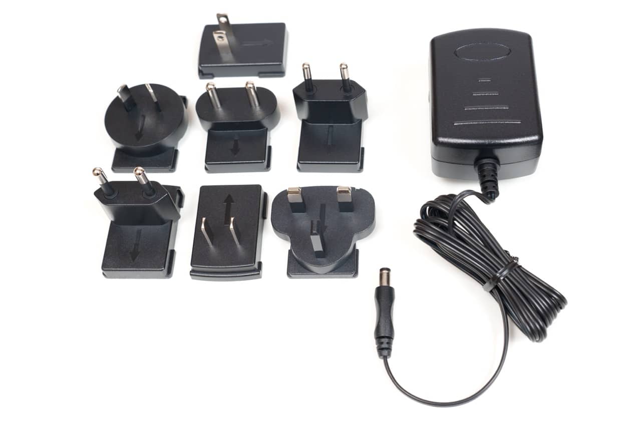 Power adapter showcased with various interchangeable plug types, arranged on a clean white background.